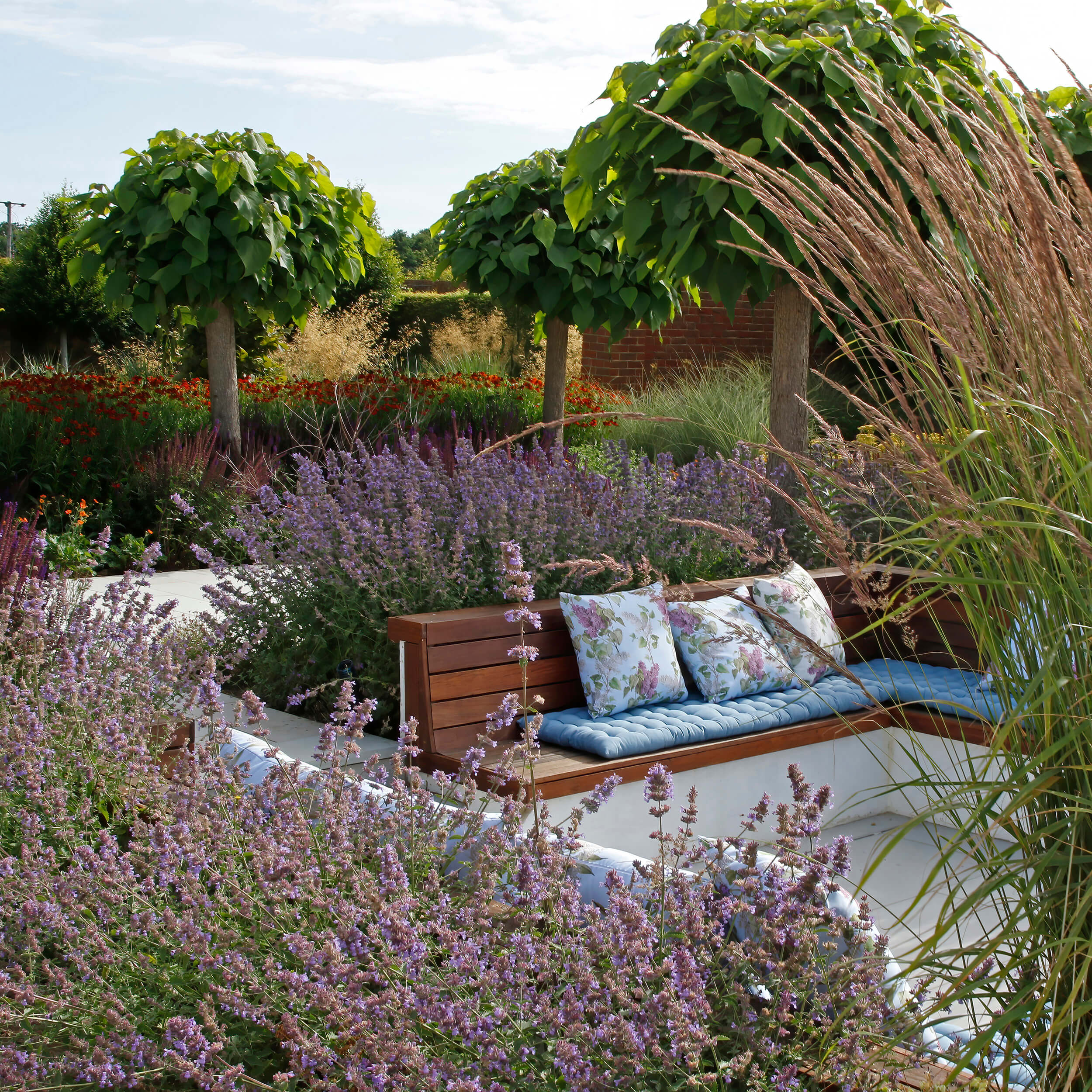 Statuesque clipped Catalpa trees feature in the colourful perennial borders surrounding the sunken seating