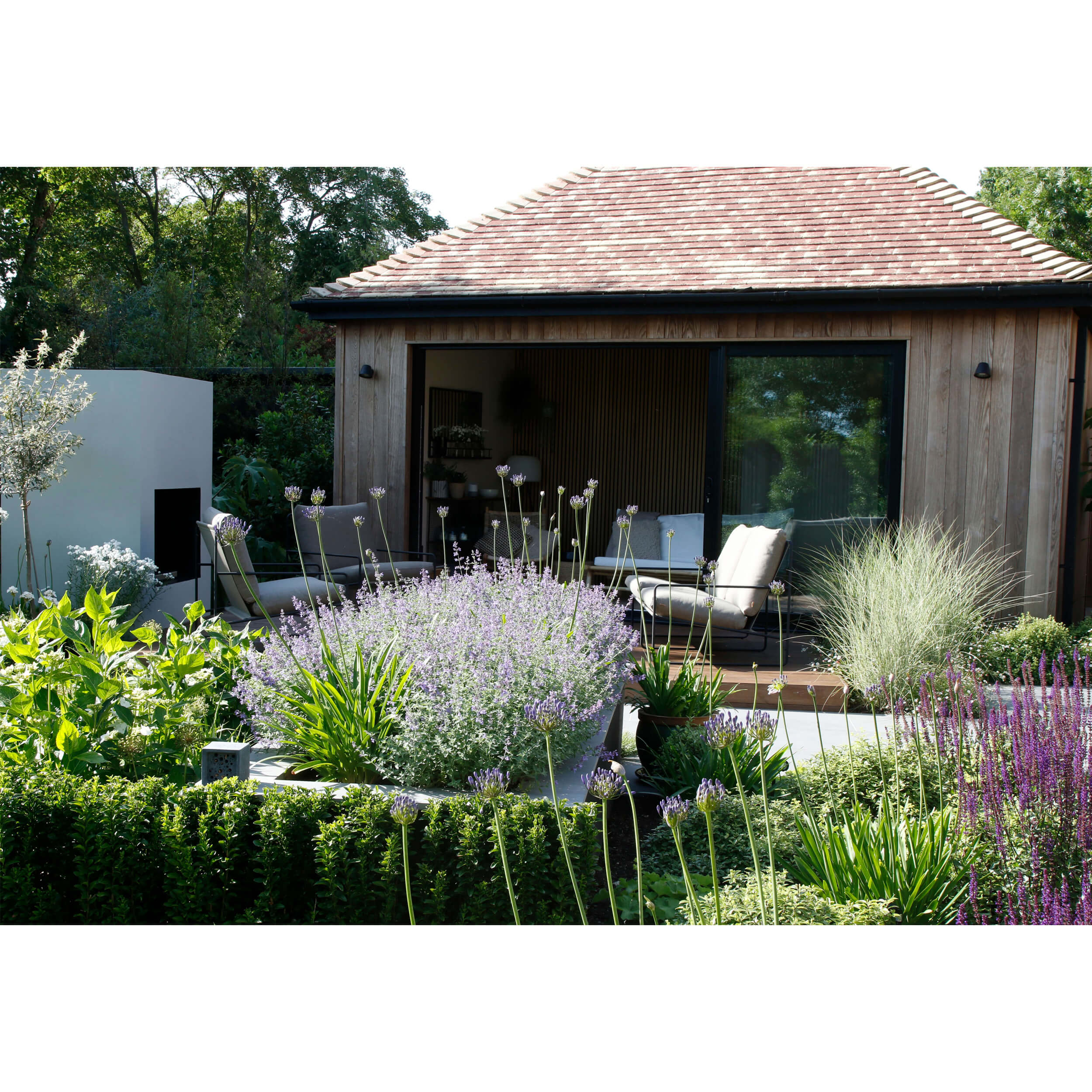 An old garage given new life transformed into a stunning garden room with feature outdoor fireplace and terrace